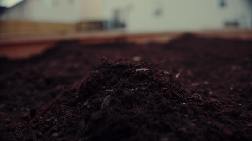 A person placing mulch on a yard
