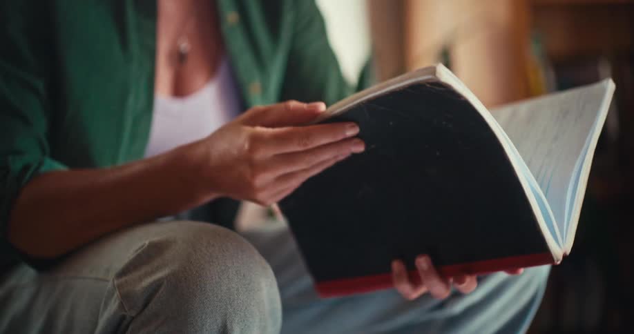 A person reading a book while sitting comfortably indoors