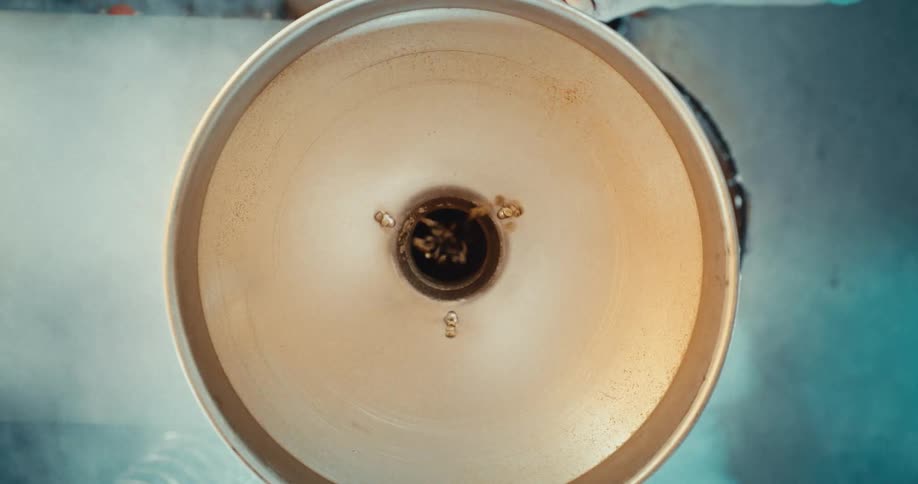 Coffee beans spinning inside a circular metal container