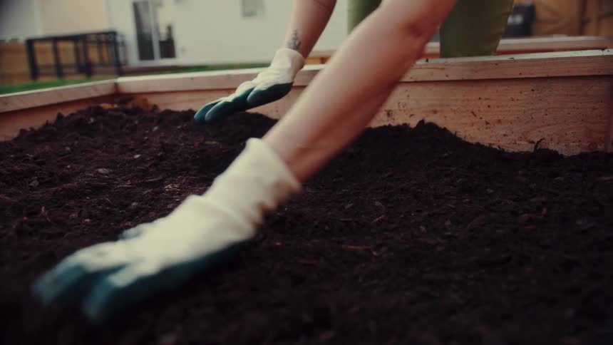 A woman working with some soil in a garden