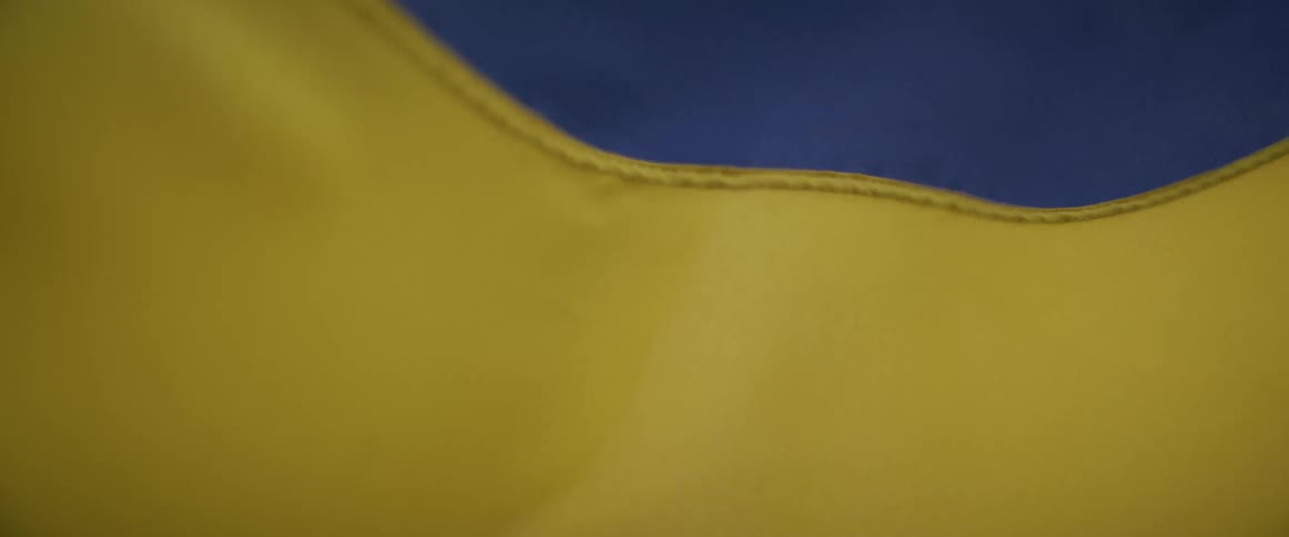 A close view shows the blue and yellow fabric of a ukrainian flag rippling and moving gently in the wind