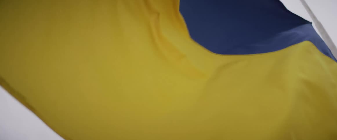 Torn blue and yellow flag waves in the wind