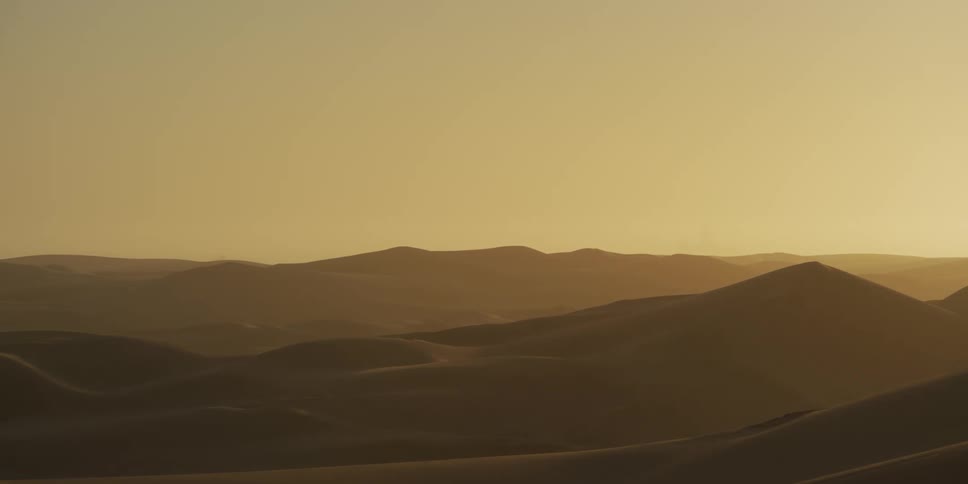 Dunes form soft layers on the illuminated desert horizon