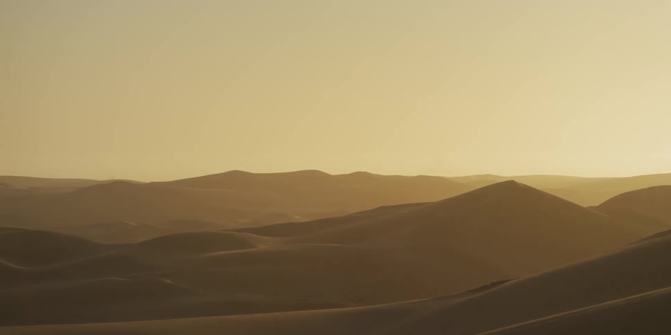 Successive dunes stretch across the illuminated desert horizon