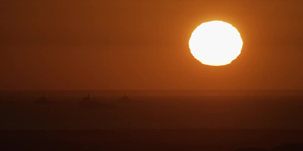 The sun is rising on the fog filled desert