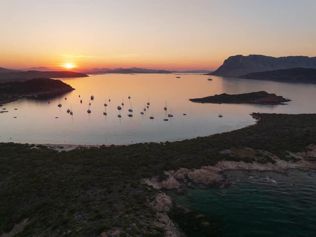 Sunset over bay with islands and anchored boats