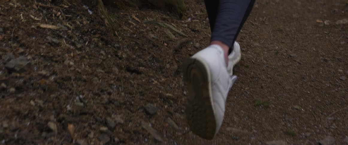 A woman running down a trail