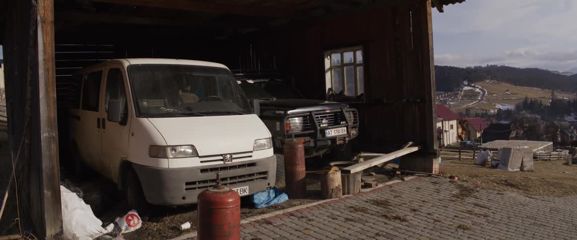 There are two distinct horizontal lines that stand out in the structural compositionthe first is the long wooden beam or plank resting horizontally across support blocks in the foreground stretching toward the open side of