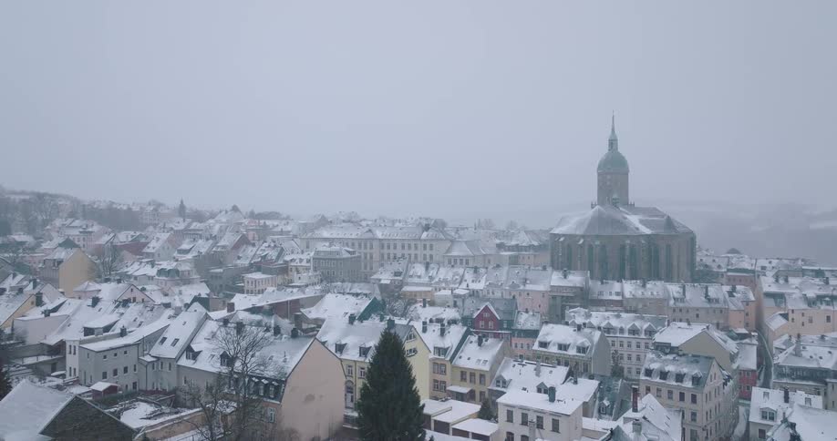 Snowcovered town with large domed church in the background