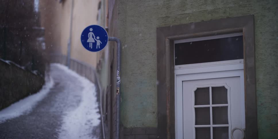 Shared pedestrian path sign on narrow snowy street