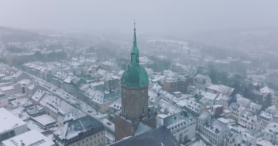 Aerial view of snowcovered town with church tower at the center