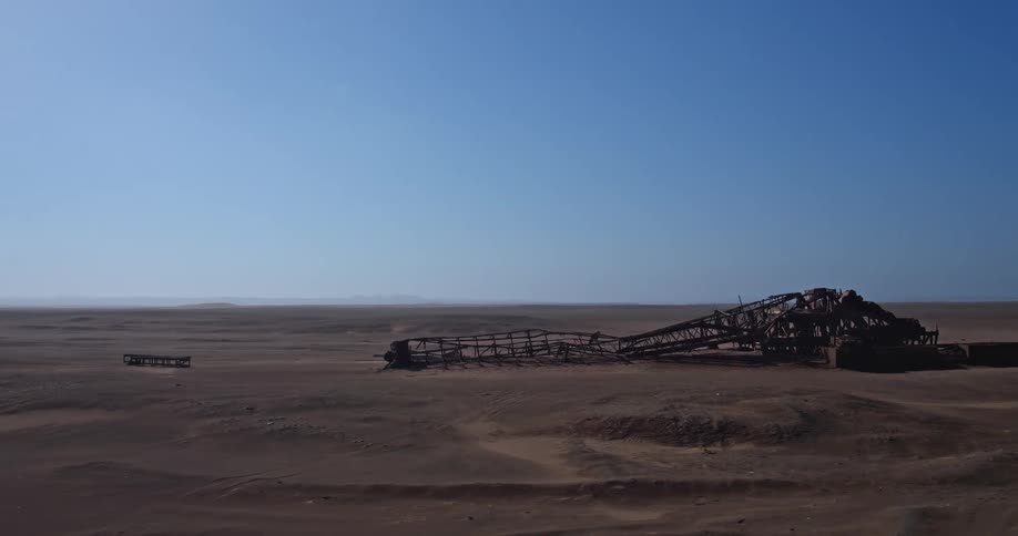 Rusting industrial structure abandoned in desert plain