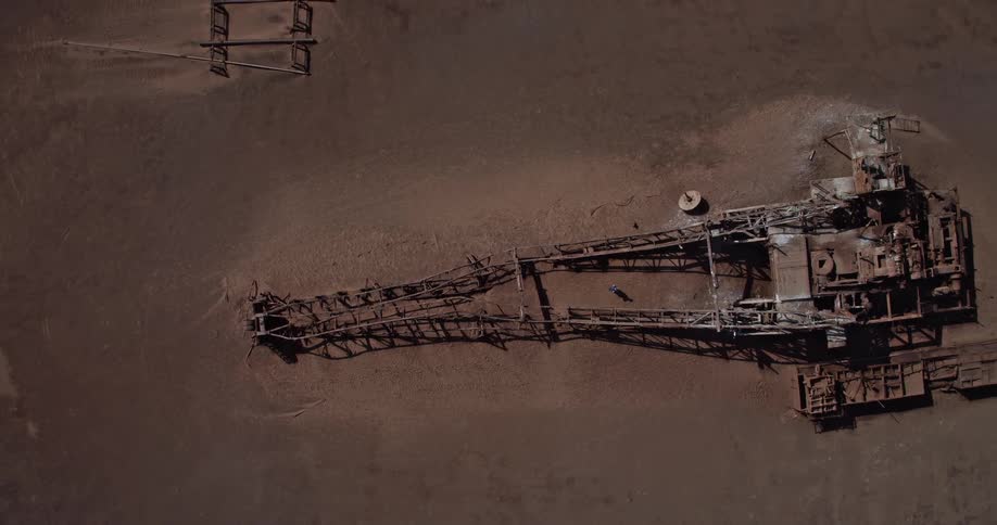 A massive bucketwheel mining excavator in a large dryland mining area