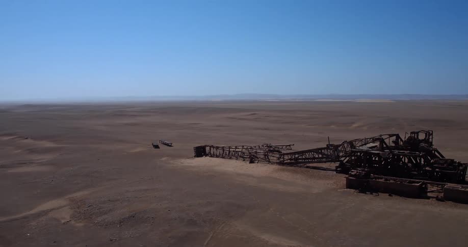 An excavator in the desert sand at midday