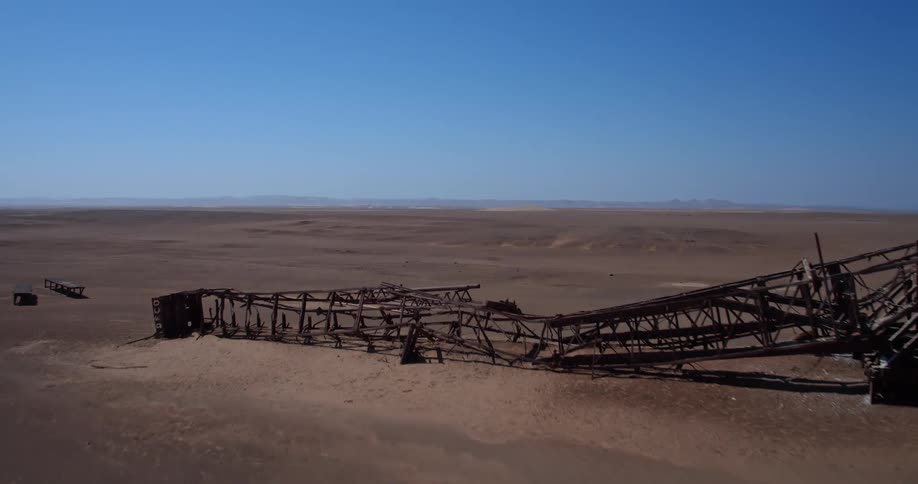 An excavator at a mining site in the desert at midday