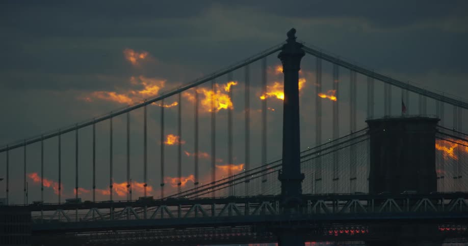 Cars driving over a bridge at sunset