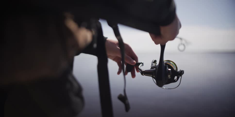 A person reeling in a fishing reel