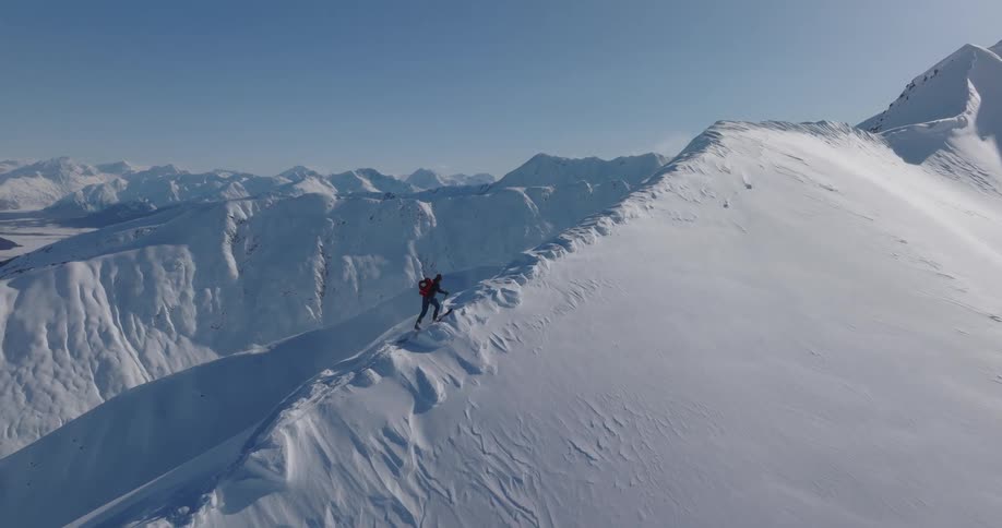 A person hiking up a snow covered mountain