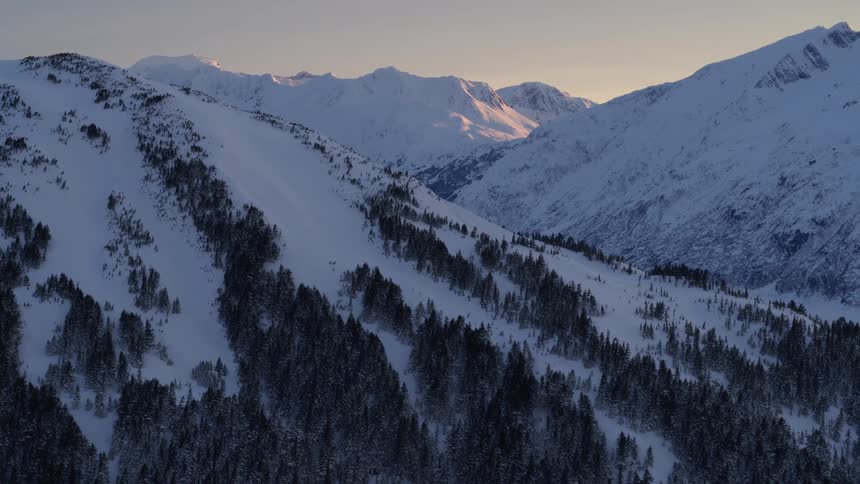 Snow covered forested mountains across the landscape