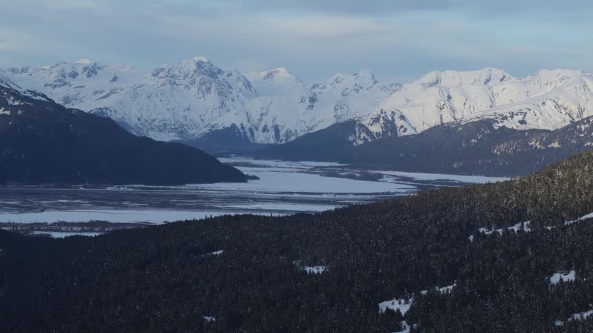 The snow covered mountains line the river bed