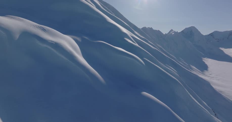 Heavy snow covers slopes with dips in a mountain range on a winter day