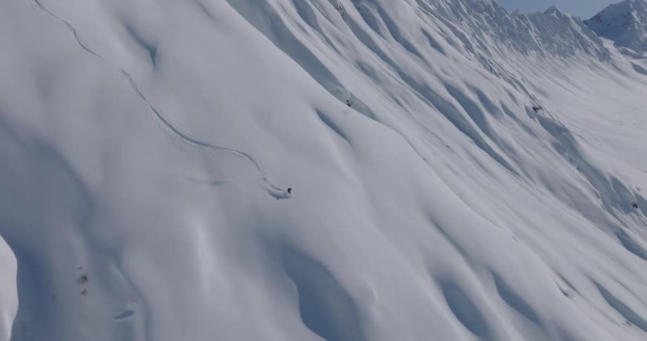 An aerial view of a man skiing down a large mountain