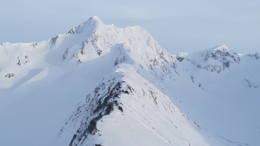 The tall mountain peak is covered with heavy snow