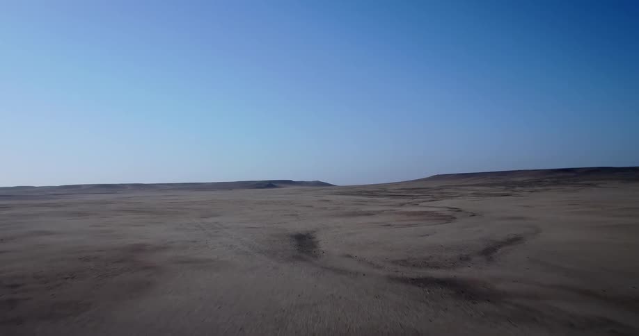 Point of view shot traveling fast across a desert landscape under a clear blue sky