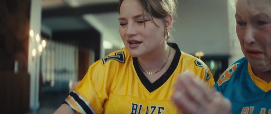 A slow-motion close-up of a young woman and her grandmother reacting with disappointment and sadness while watching a football game