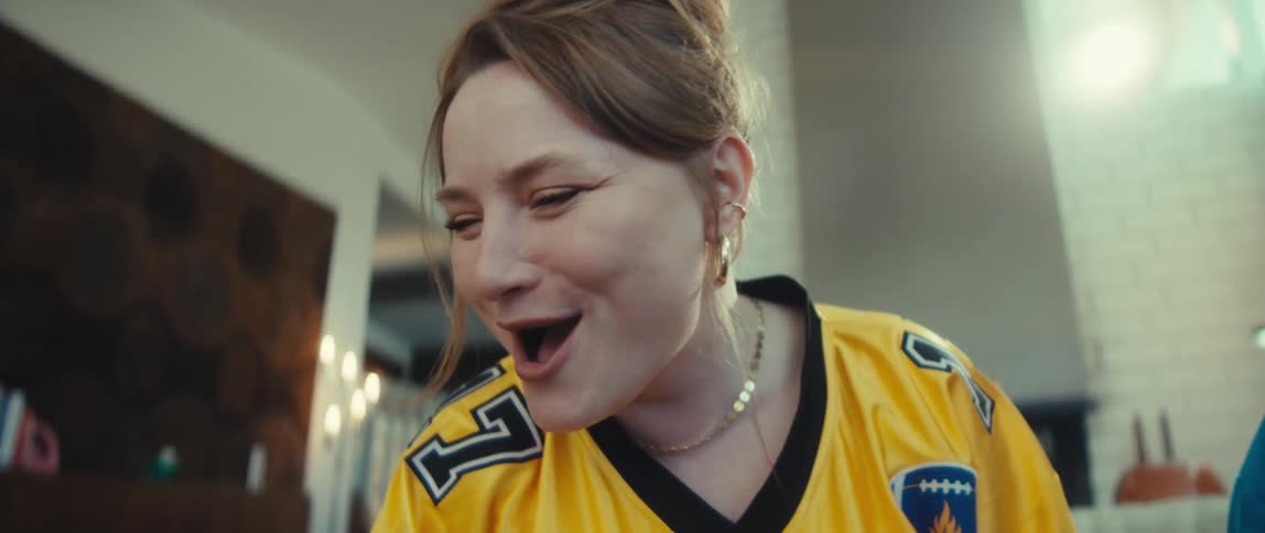 Two female football fans of different generations erupt in celebration while watching a game at home