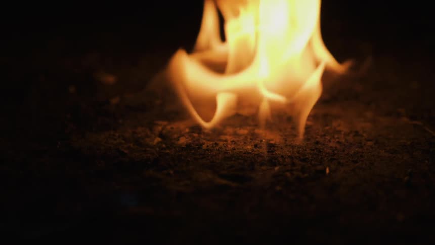 A flame burns on the ground