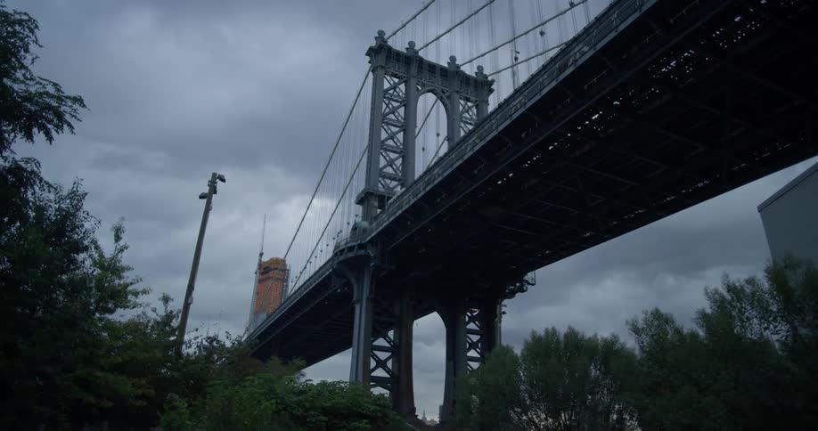 A city bridge is shown from below on an overcast day