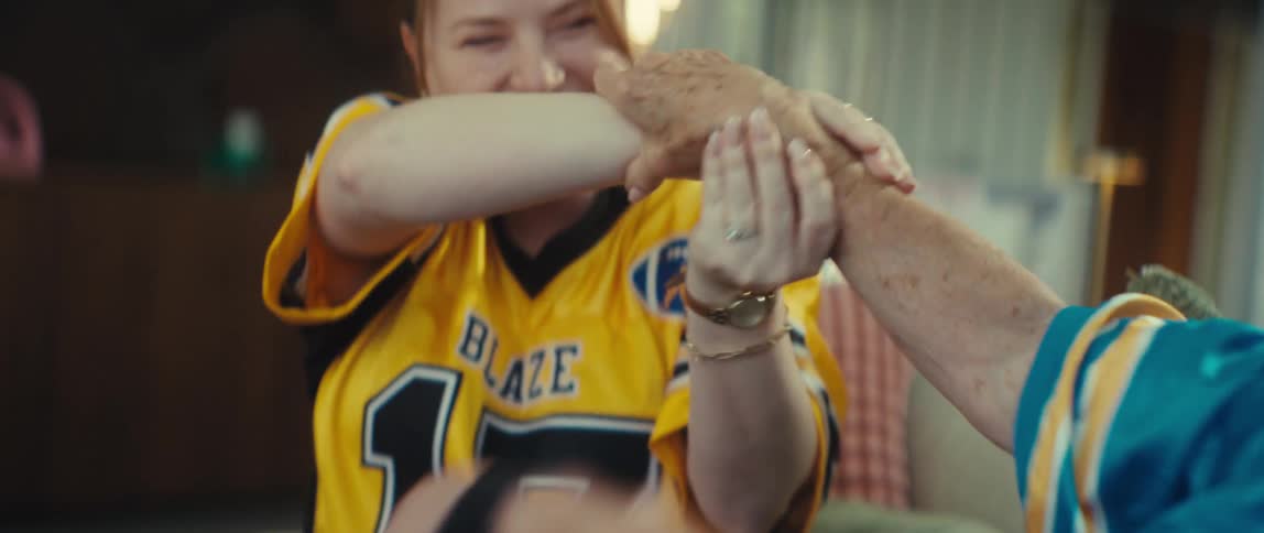 A group of female football fans celebrate an exciting victory and hug each other with tears of joy