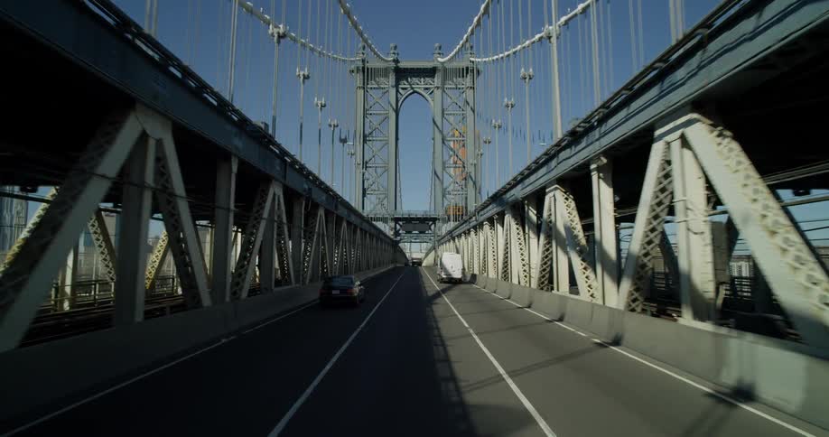 Vehicles moving across a bridge in daytime