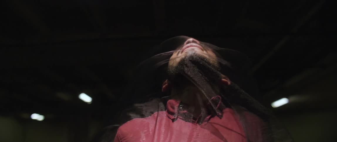 A supernatural figure wraps around a man's face
