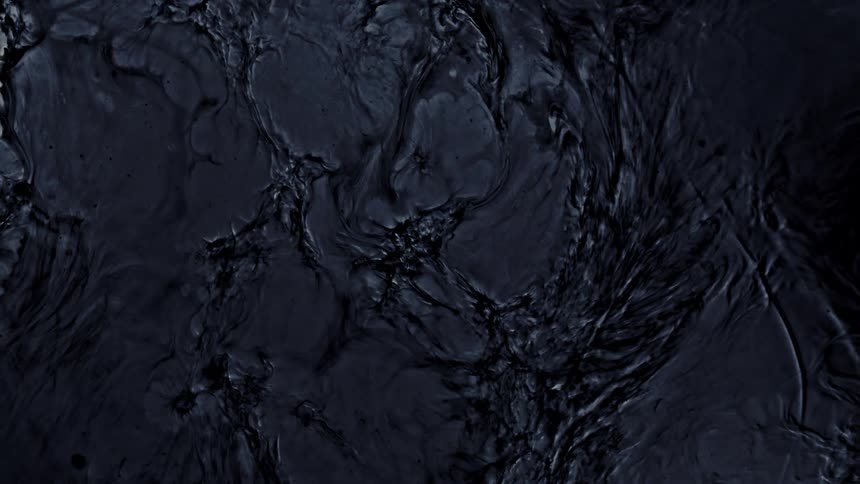 A dark, viscous liquid shifts and solidifies in an abstract, slow-motion display