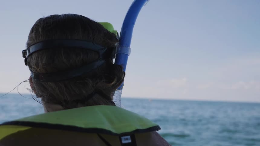 A woman is ready to snorkel at sunset