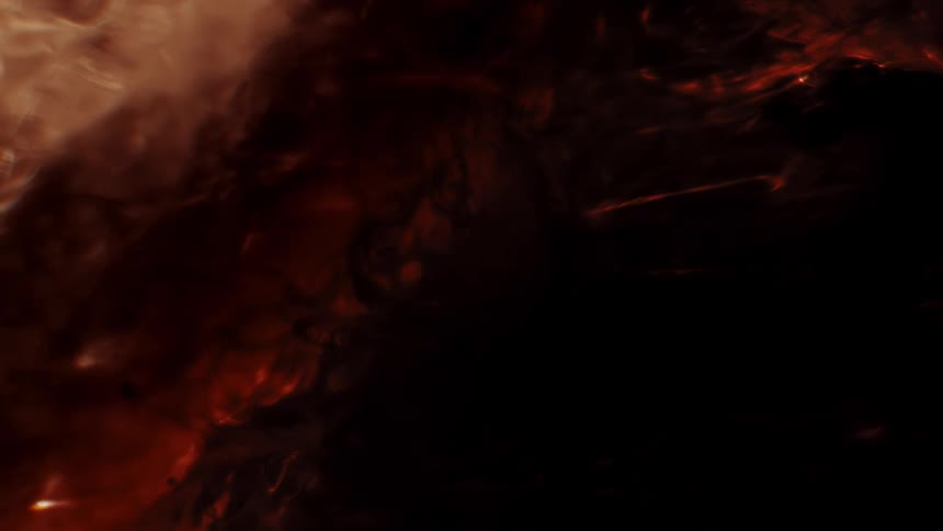 Dark, smoky red embers and black ash slowly swirl together in a mysterious, abstract close-up