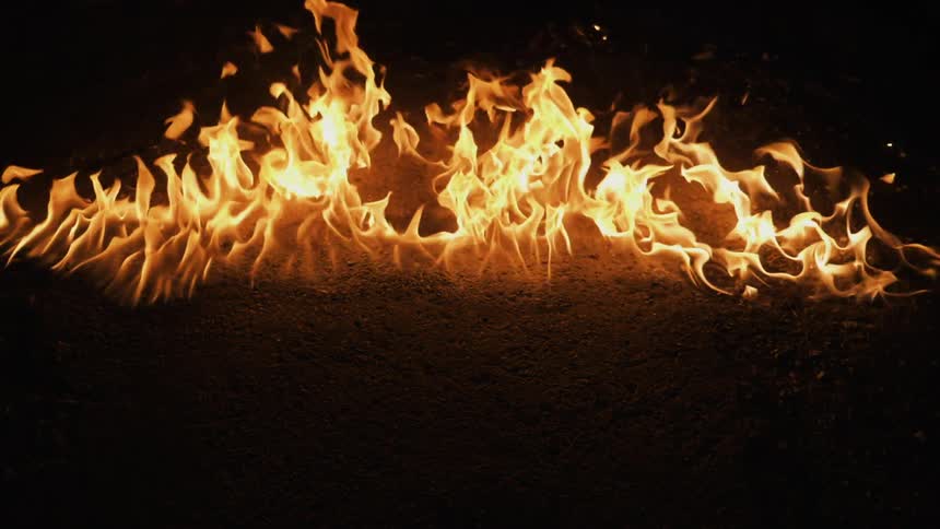 A fire moves across the dark floor