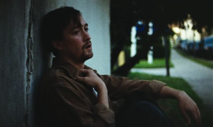 An anxious man sits on the curb trying to calm down