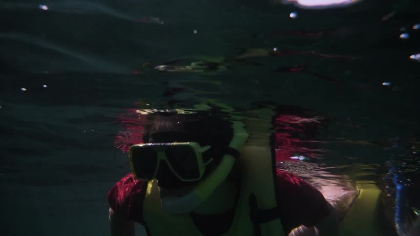 Female snorkeler looks around