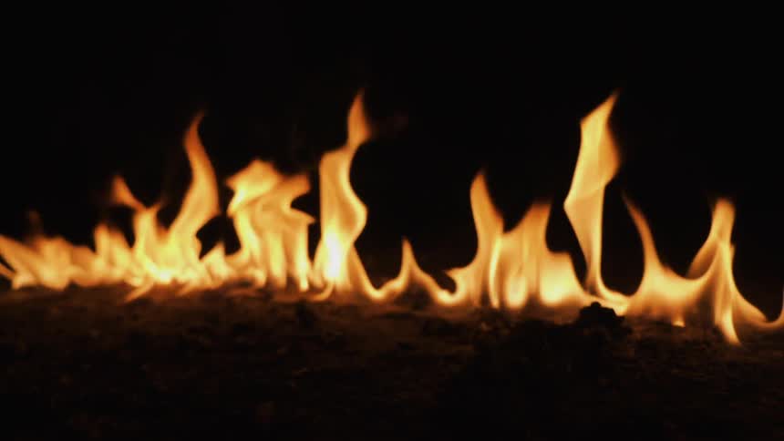 A fire is blazing in a line in the dark