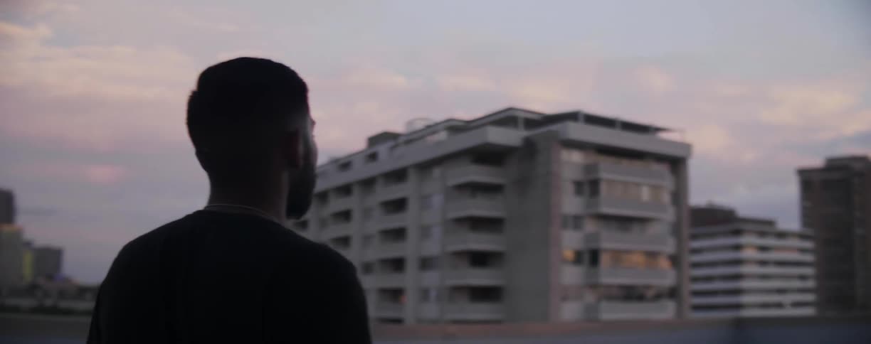 Man with a beard walks around city at dusk