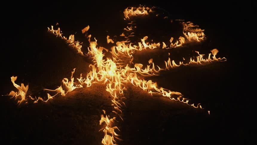 A flame burns across the night ground into a shape