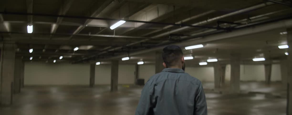 A man walks through an empty parking garage