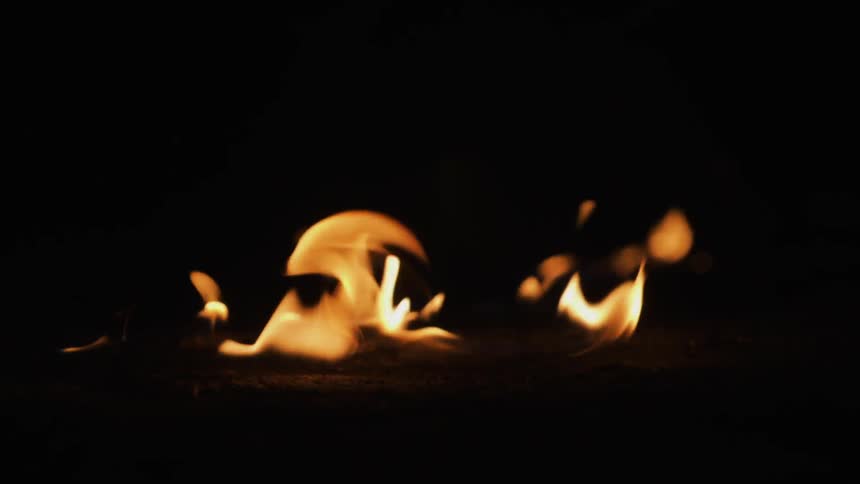 A fire burns on the ground