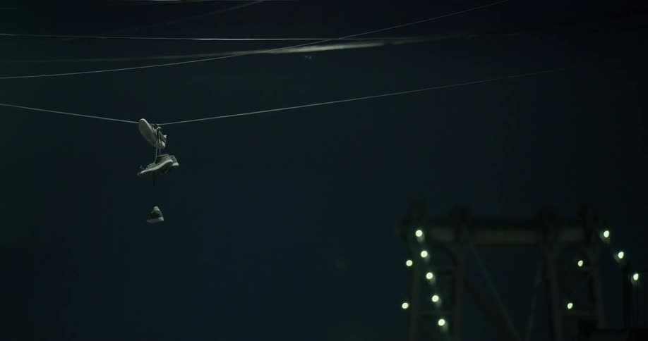 Tennis shoes hang from wires overhead