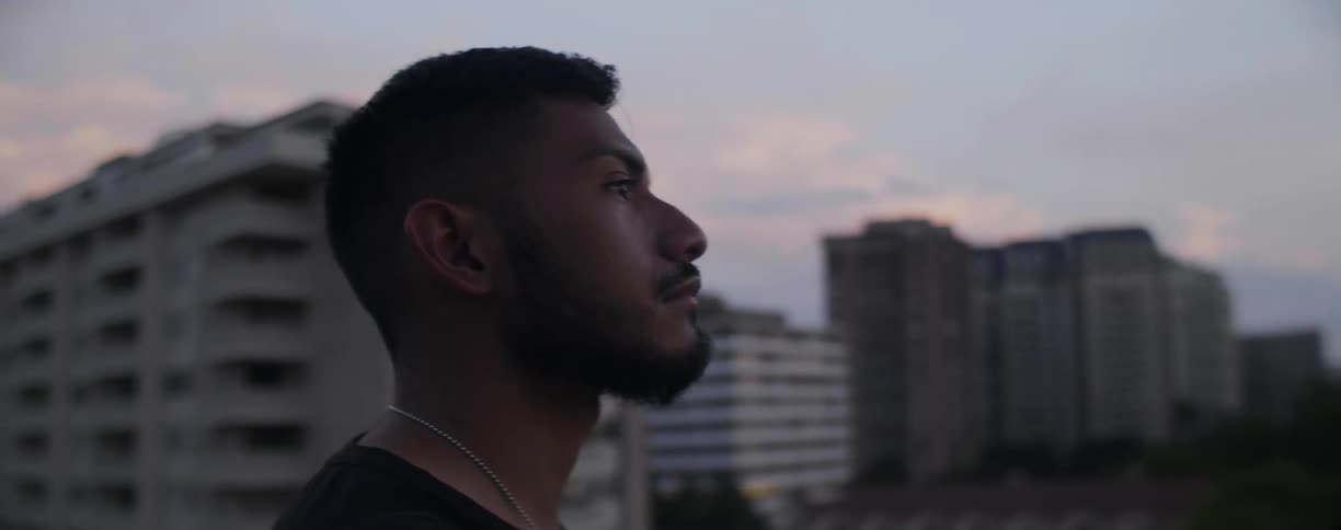A man overlooks a city at sunset