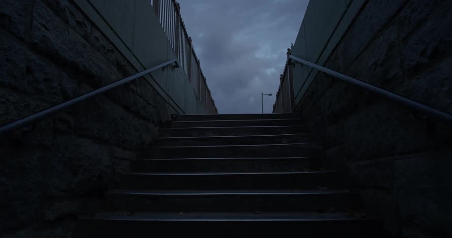 Dark clouds hover over a stairwell at dusk or dawn