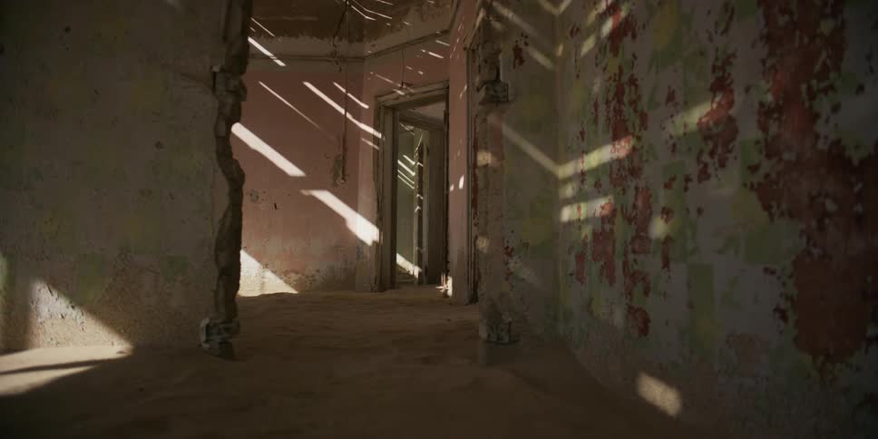 A time-lapse of sunlight and shadows moving across the sandy floors and decaying walls of an abandoned desert home